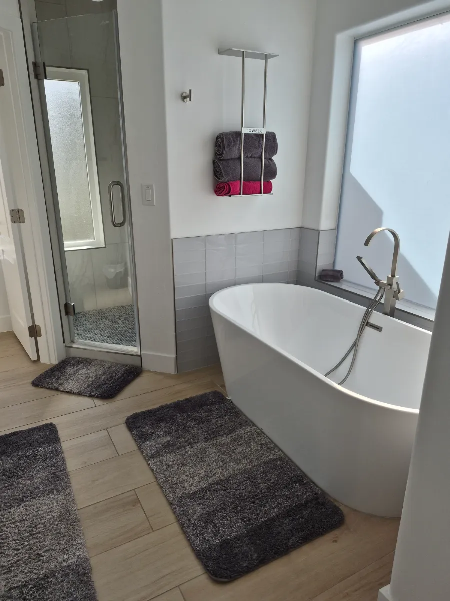 Freestanding tub, glass shower and floors left gleaming, cleaned by Tidy Up Solutions Cleaning Services in the Phoenix area